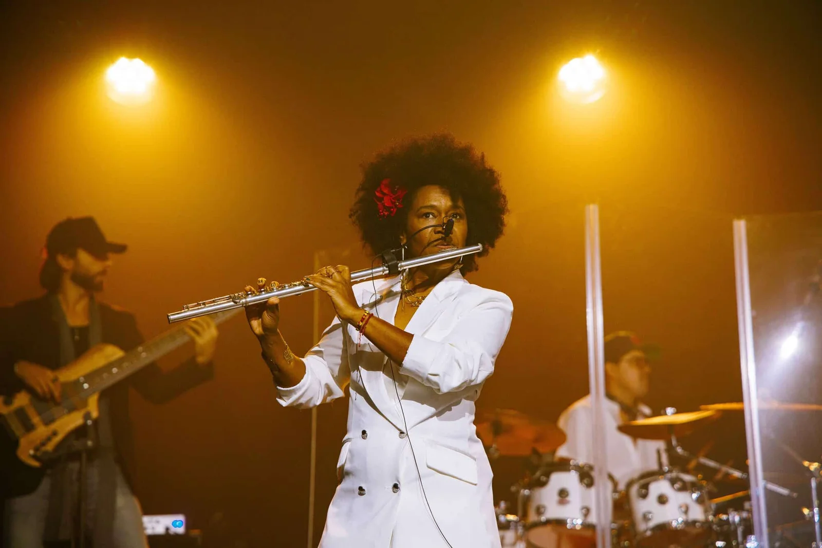Magela Herrera playing flute on a golden-lit stage
