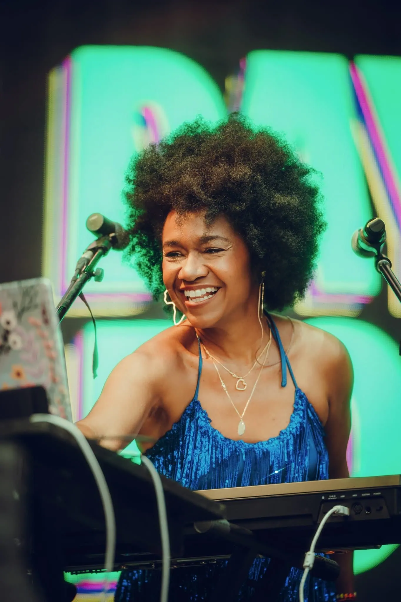 Magela Herrera smiling at the keyboard in a blue sequined dress